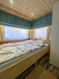 a large bed in a room with a wooden ceiling at Къмпинг Alino Lake in Alino