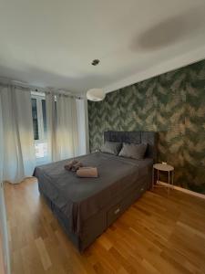 a bedroom with a large bed with green wallpaper at SARA Apartment EAST GATE LIVING in Skopje +18 photos