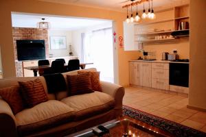a living room with a couch and a kitchen at Anyskop Guest Farm in Langebaanweg