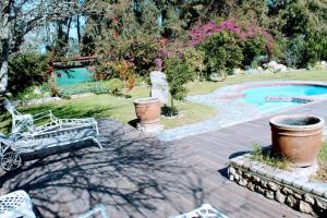 a garden with a bench and a swimming pool at Anyskop Guest Farm in Langebaanweg