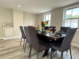a dining room with a black table and chairs at The Refuge, Wendover in Wendover