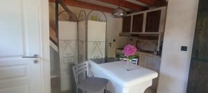 a kitchen with a white table and a vase of flowers at Camélias in Laboutarié