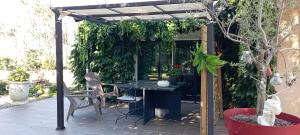 a pergola with a table and chairs in a garden at Camélias in Laboutarié