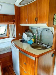 a kitchen with a sink and a mirror in an rv at Къмпинг Alino Lake in Alino +150 photos