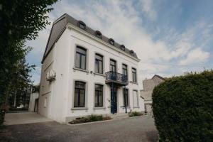 a white building with a balcony on top of it at Designer Hôtel in Heusy