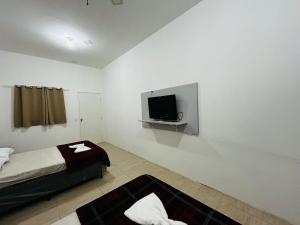a bedroom with a bed and a flat screen tv at Studio espaçoso em São Paulo no bairro Tucuruvi in Sao Paulo