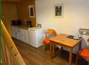 a small kitchen with a table and a refrigerator at Hotel Schachten in Lindberg