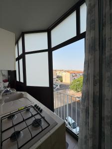 une cuisine avec une cuisinière et une vue sur une rue dans l'établissement Holiday House Civic 27, à Catane