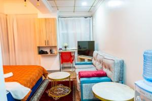 a small room with a bed and a couch at Villaroma Furnished Penthouse Suites in Eldoret