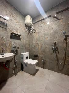 a bathroom with a shower and a toilet and a sink at Azalea Holidays On Mall in Darjeeling
