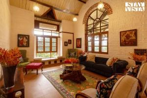 a living room with a couch and a table at StayVista at Orchard by the River with Bonfire, BBQ in Karjat