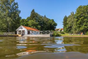a small building next to a body of water at Villa Kolartorp in Ekolsund