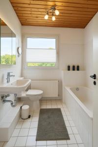 a bathroom with a sink and a tub and a toilet at Cozy City Apartments 3, 2-Room Flat for Vacation & Messe Düsseldorf, Perfect Connectivity in Ratingen