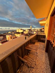 a balcony with two chairs and a view of the city at Casa grande en Garachico centro in Garachico