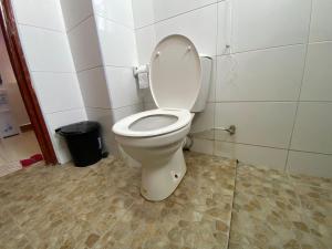 a bathroom with a toilet with the lid up at Cozy & Modern One Bedroom Opposite Garden City Mall in Nairobi +20 photos