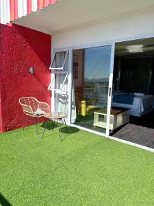 a room with a balcony with a bed and a table and chairs at Nkandla Lifestyle in Mthatha