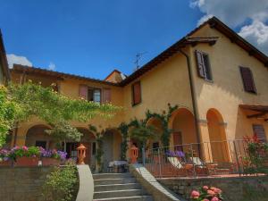 ローロ・チュッフェンナにあるModern Holiday Home in Loro Ciuffenna with Poolの階段と椅子が前にある家