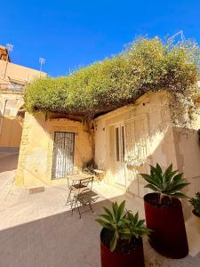 a building with a patio with a table and plants at CASì in Noto