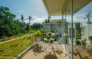a balcony of a house with a table and chairs at Paradise House - 1BR - Calm & Green Garden Stay - Heart of Thong Sala - 4K SmartTV in Koh Phangan