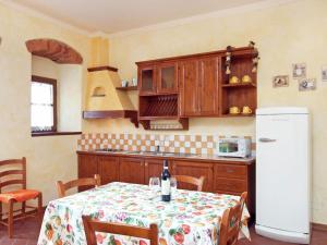 Una cocina con una mesa y un refrigerador blanco. en Modern Holiday Home in Loro Ciuffenna with Pool, en Loro Ciuffenna
