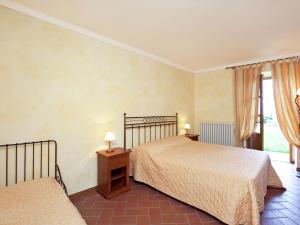 Un dormitorio con dos camas y una ventana. en Modern Holiday Home in Loro Ciuffenna with Pool, en Loro Ciuffenna