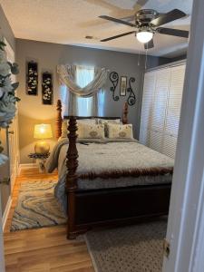 Un dormitorio con una cama con ventilador de techo. en Hank and Margie's Place, 