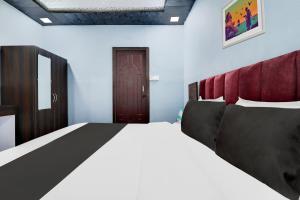 a bedroom with a large bed and a wooden door at Hotel O Dharohar in Rishīkesh +20 photos