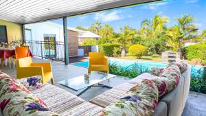 a living room with two couches and a view of a pool at Villa Solaya -Piscine - Saint Pierre in Saint-Pierre