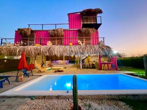 a villa with a swimming pool in front of a building at Mojarra Beach-Wind Room- Santa Veronica in Salina de Rey