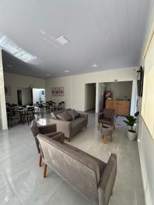 a living room with couches and chairs and a table at Vithor Hotel in Cassilândia +24 photos