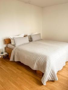 une chambre avec un grand lit avec des draps blancs dans l'établissement Klosterblick, à Inzigkofen