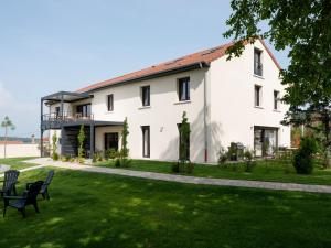 a large white building with chairs in the grass at La Ferme d'Estelle in Vulmont