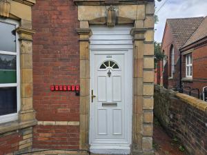 a white door on the side of a brick building at Nice Room 6 in Avonmouth +3 photos