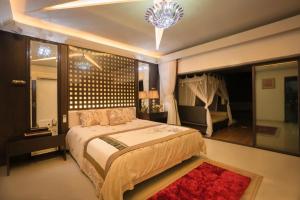 Un dormitorio con una cama grande y una lámpara de araña. en Andy's Boutique Hotel, en Bombay