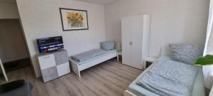a small living room with a couch and a tv at Monteurwohnung in Arzberg