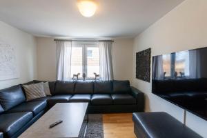 a living room with a black leather couch at Ferienhaus Malte in Braunlage