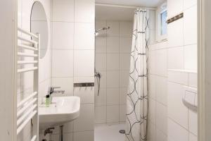 a white bathroom with a sink and a shower at Ferienhaus Malte in Braunlage +38 photos