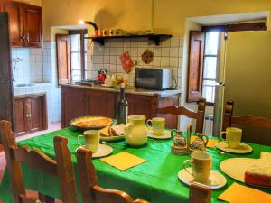 cocina con mesa y mantel verde en Farmhouse in Umbria near Palazzo Bourbon, en Monte Santa Maria Tiberina