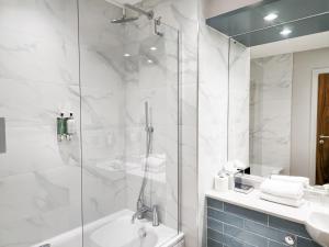 a bathroom with a shower and a tub and a sink at Smiths At Gretna Green Hotel in Gretna Green +65 photos