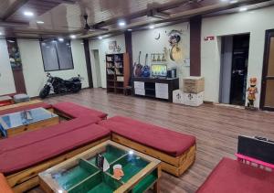 Una sala de estar con sofás rojos y un televisor. en The Mountain View Tapovan, en Narendranagar