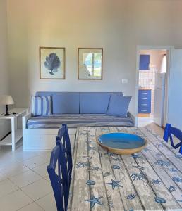 a living room with a blue couch and a table at Casa Anna - Capo Perla Apartments in Capoliveri