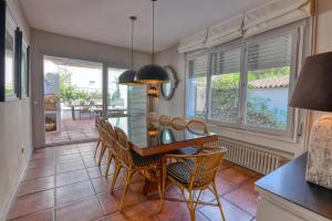 a dining room with a table and chairs and windows at House with private pool in Calella de Palafrugell