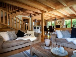 a living room with two couches and a table at Chalet Evelyn - OVO Network in Morzine