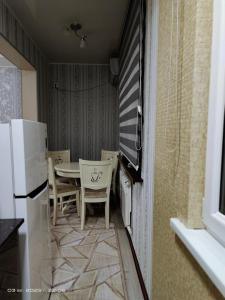 Una cocina con mesa y sillas y un refrigerador. en ЮнусАбад, en Yunusobod