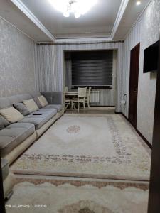 una sala de estar con un sofá y una mesa en ЮнусАбад, en Yunusobod