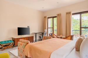 a bedroom with a bed and a tv at Casa Suneos 4-BHK Villa With Private Pool & Lift Near Popular Restaurants in Siolim