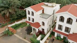 een uitzicht op een wit huis met een rood dak bij Casa Verdea 4-BHK Villa With Private Pool & Lift Near Popular Restaurants in Siolim