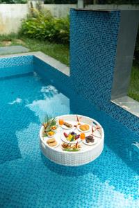 a plate of food on top of a swimming pool at Casa Suneos 4-BHK Villa With Private Pool & Lift Near Popular Restaurants in Siolim