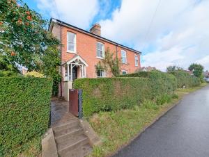 a brick house with a gate and stairs in front at Brambletye Cottage - Westbourne in Westbourne