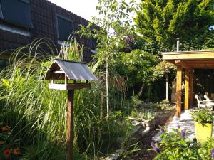 a bird house in the middle of a garden at KNUS tiny gardenhouse in Doorn +21 photos